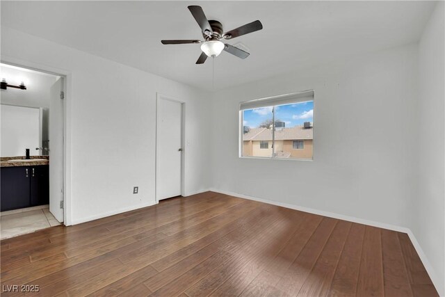 3891 Terrazzo Ave, Las Vegas, NV 89115 - unfurnished bedroom featuring ensuite bathroom, hardwood / wood-style flooring, baseboards, a ceiling fan, and a sink