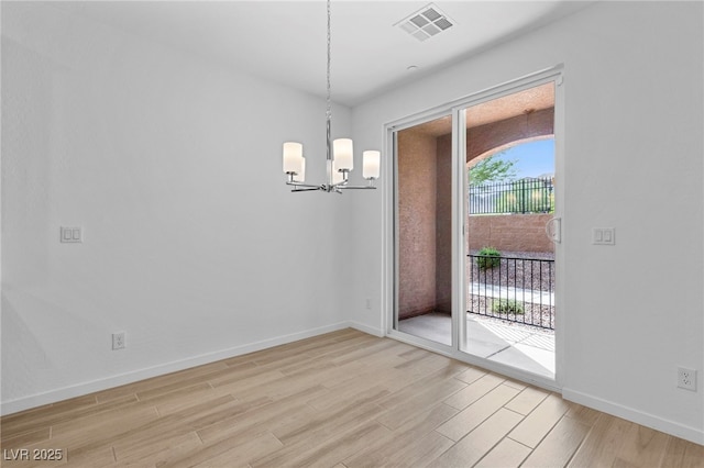 unfurnished dining area featuring light hardwood / wood-style flooring and a notable chandelier