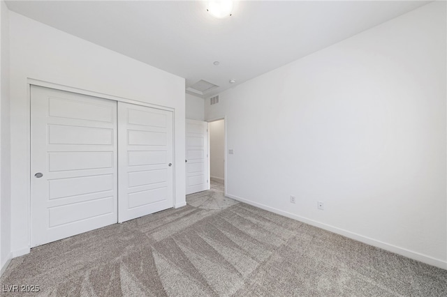 unfurnished bedroom with light colored carpet and a closet