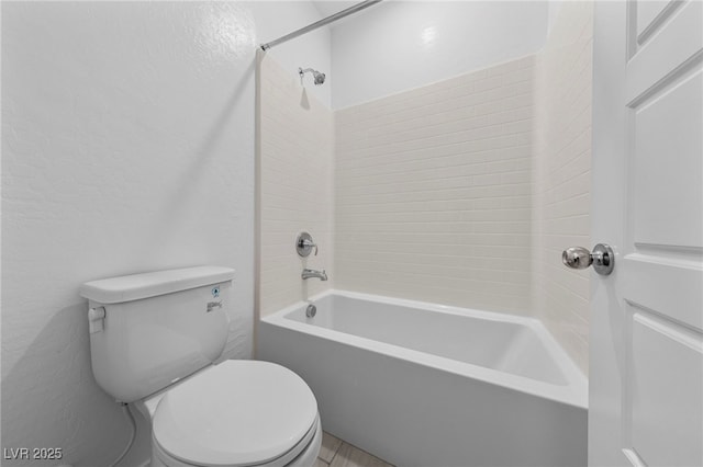 bathroom with washtub / shower combination and toilet