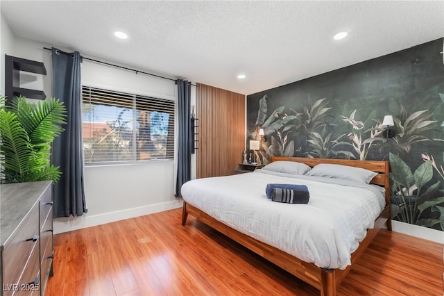 bedroom featuring light hardwood / wood-style flooring and a textured ceiling