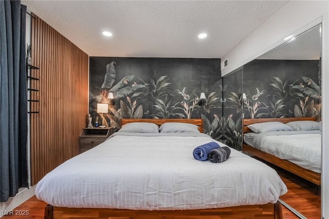 bedroom with hardwood / wood-style flooring and a textured ceiling