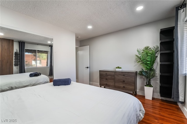 bedroom with dark wood-type flooring and a textured ceiling