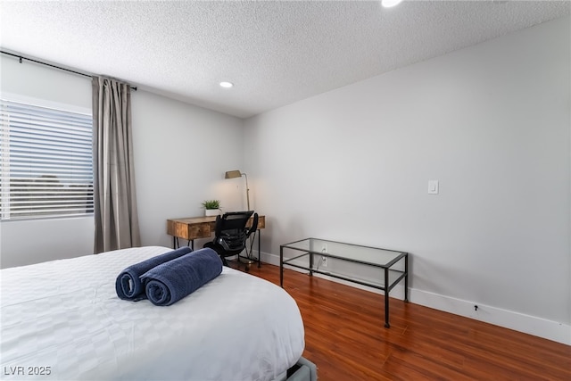 bedroom with wood-type flooring and a textured ceiling