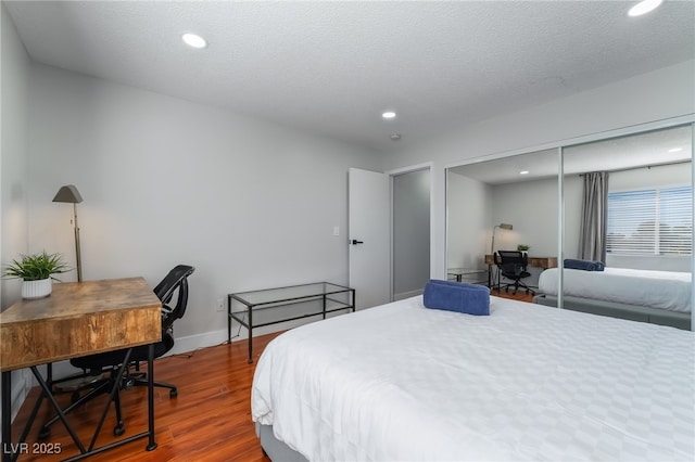 bedroom featuring hardwood / wood-style flooring, a closet, and a textured ceiling