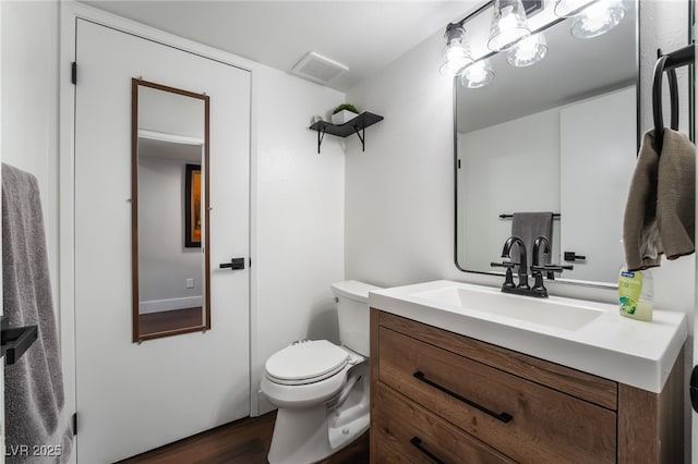 bathroom with vanity, toilet, and hardwood / wood-style floors