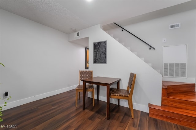 dining space with dark hardwood / wood-style flooring and a textured ceiling