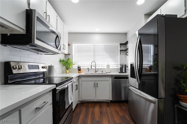 kitchen with dark wood-type flooring, appliances with stainless steel finishes, sink, and white cabinets