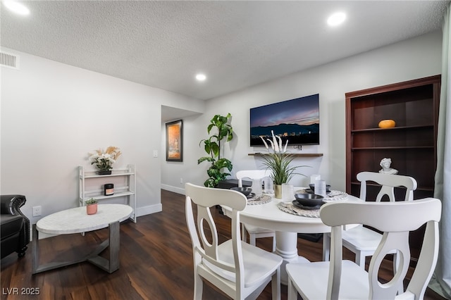 dining room with dark hardwood / wood-style flooring and a textured ceiling