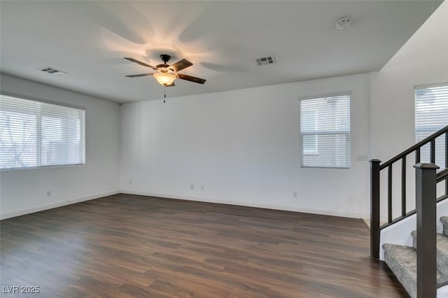 unfurnished room featuring ceiling fan, plenty of natural light, and dark hardwood / wood-style flooring