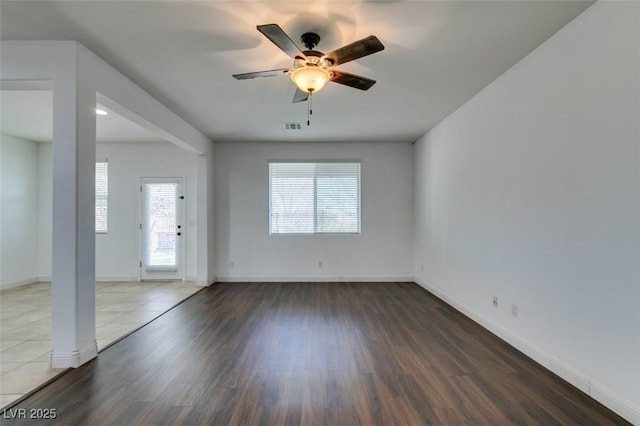 empty room with dark hardwood / wood-style flooring and ceiling fan