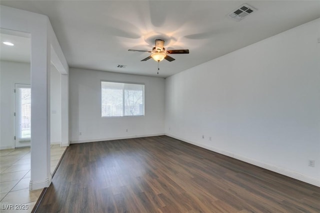 empty room featuring dark hardwood / wood-style flooring and ceiling fan