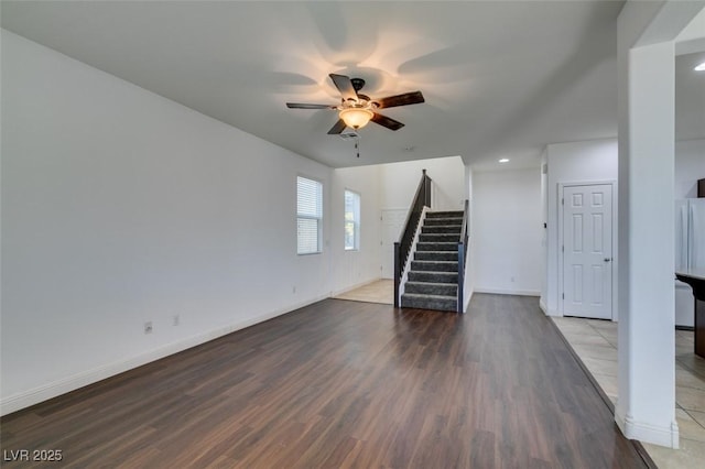 unfurnished living room featuring ceiling fan and dark hardwood / wood-style floors