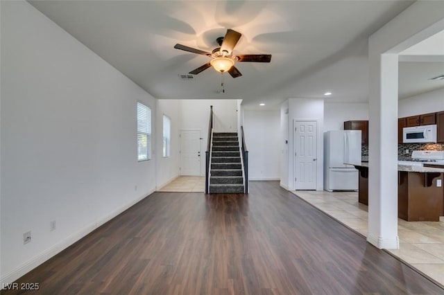 unfurnished living room with ceiling fan and light wood-type flooring