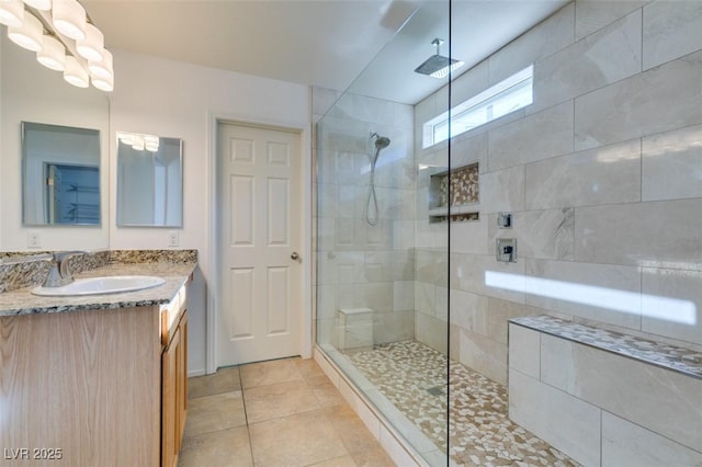 bathroom with vanity, a tile shower, and tile patterned floors