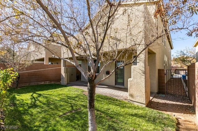 rear view of house with a patio and a yard