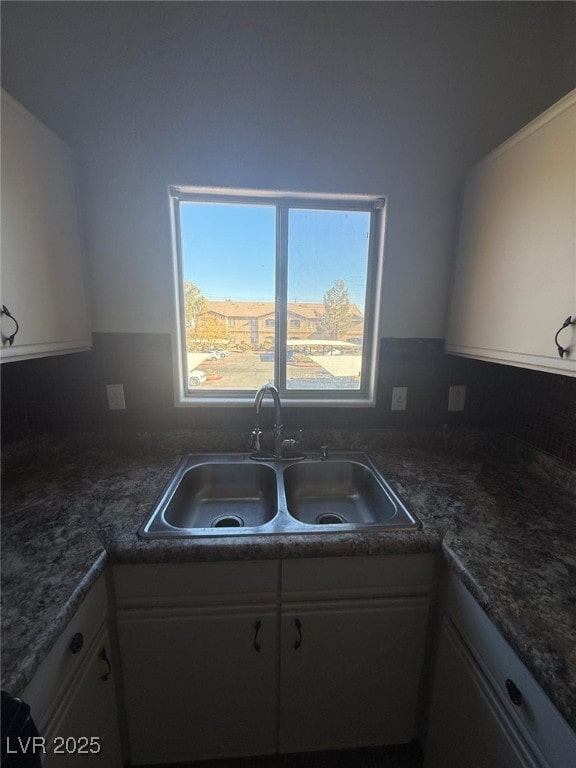 kitchen featuring white cabinetry and sink