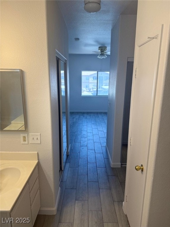 hallway with sink and a textured ceiling