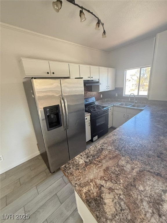 kitchen featuring sink, rail lighting, white cabinetry, gas stove, and stainless steel fridge with ice dispenser