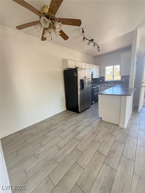 kitchen with white cabinetry, rail lighting, sink, kitchen peninsula, and stainless steel refrigerator with ice dispenser