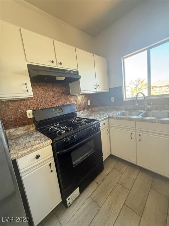 kitchen featuring sink, black gas stove, white cabinetry, ornamental molding, and decorative backsplash