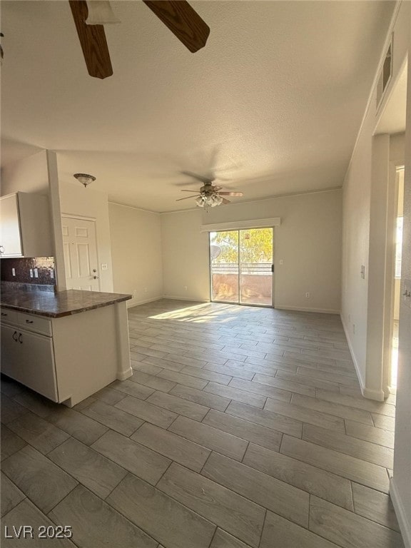 unfurnished living room with ceiling fan