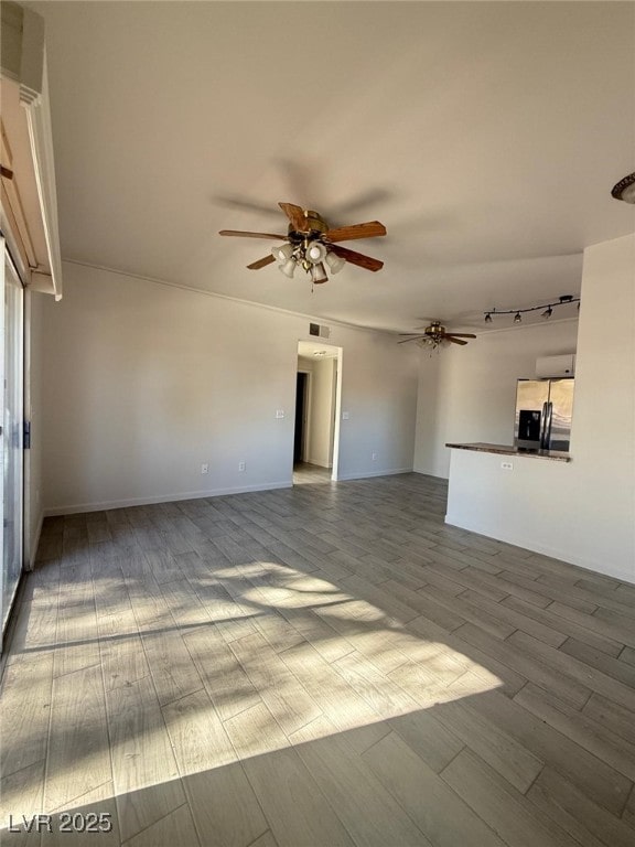 unfurnished living room featuring ceiling fan and light wood-type flooring