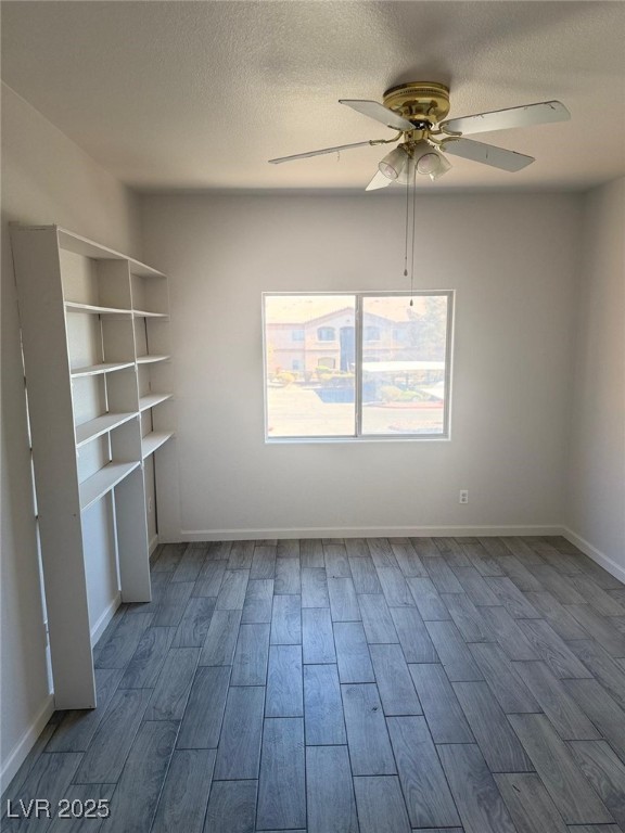 spare room with a textured ceiling and ceiling fan