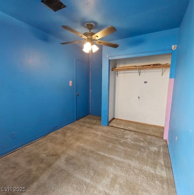 unfurnished bedroom featuring carpet, ceiling fan, and a closet