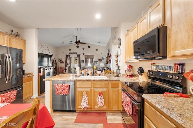 kitchen featuring light brown cabinetry, lofted ceiling, sink, kitchen peninsula, and stainless steel appliances