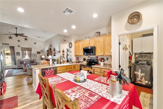 kitchen featuring lofted ceiling, sink, light hardwood / wood-style flooring, appliances with stainless steel finishes, and light brown cabinetry