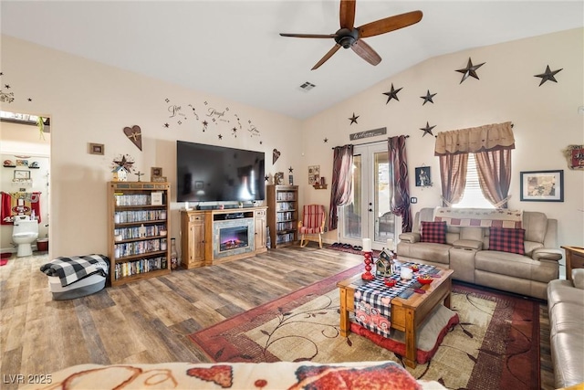 living room featuring vaulted ceiling, wood-type flooring, ceiling fan, and french doors