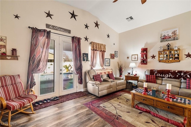 living room featuring lofted ceiling, wood-type flooring, french doors, and ceiling fan