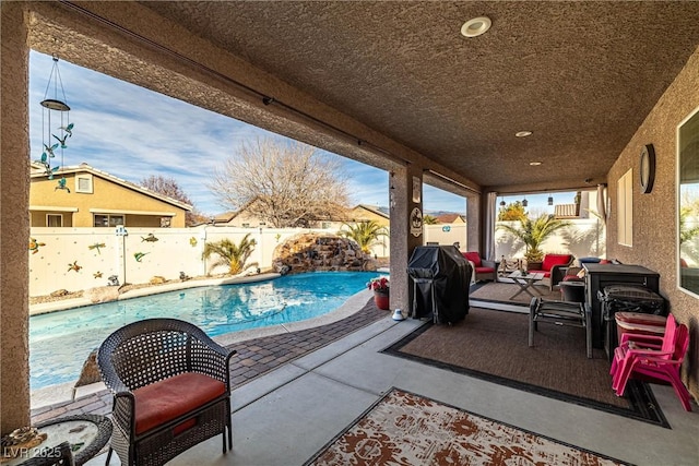 view of patio with a fenced in pool and area for grilling