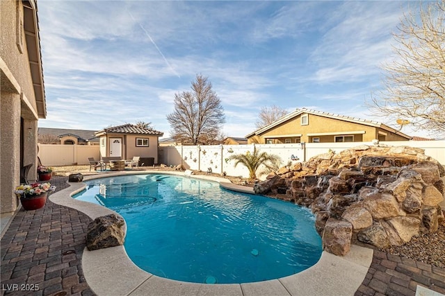 view of swimming pool featuring a patio and an outdoor structure