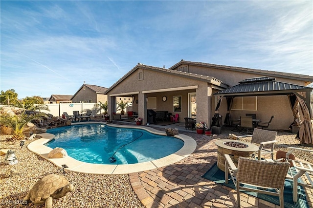 view of pool with a gazebo, an outdoor fire pit, and a patio area