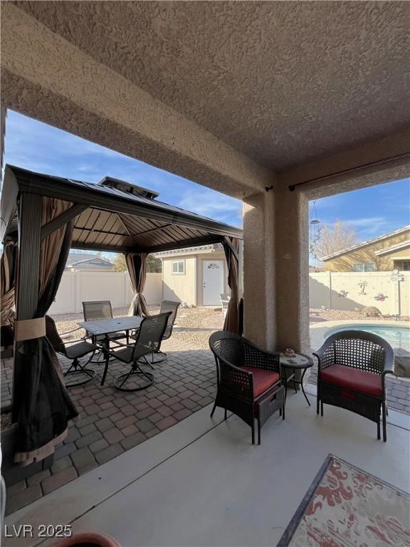 view of patio / terrace featuring a gazebo and a storage unit