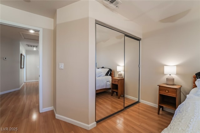 bedroom with wood-type flooring and a closet