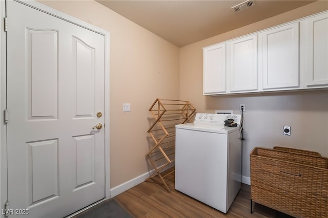 laundry area featuring washer / clothes dryer, hardwood / wood-style flooring, and cabinets