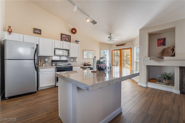 kitchen with lofted ceiling, light stone countertops, white cabinets, and white appliances