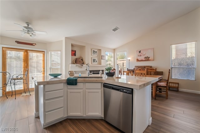 kitchen with a healthy amount of sunlight, white cabinets, lofted ceiling, and dishwasher