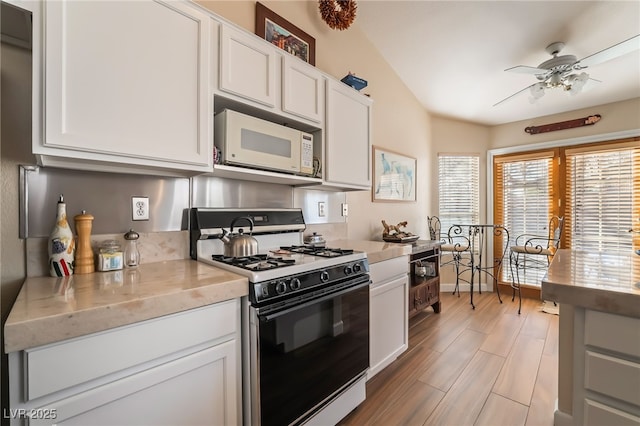 kitchen featuring white cabinetry, lofted ceiling, ceiling fan, and white appliances