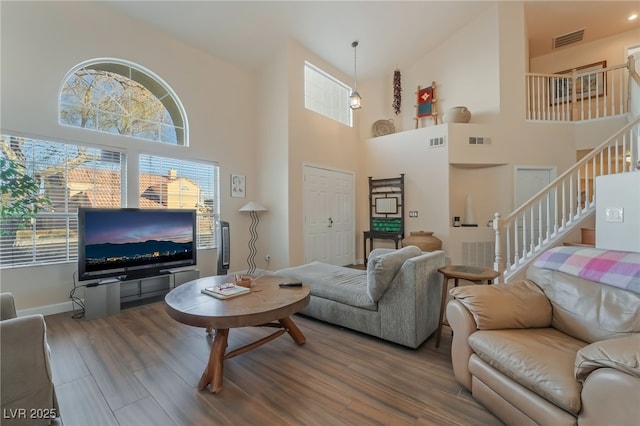 living room with hardwood / wood-style floors and a high ceiling