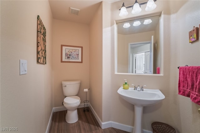 bathroom with hardwood / wood-style flooring, toilet, and sink