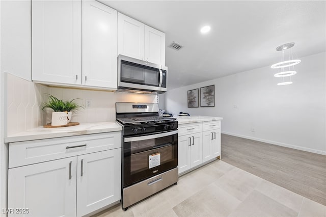 kitchen featuring pendant lighting, appliances with stainless steel finishes, and white cabinets