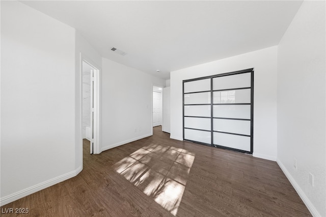 unfurnished bedroom with a closet and dark hardwood / wood-style floors