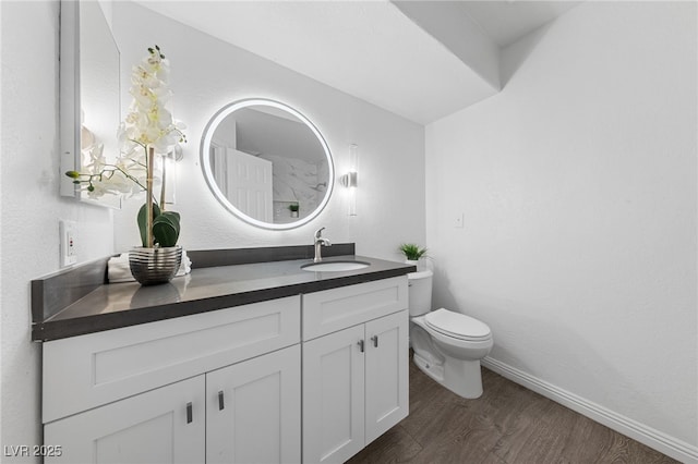 bathroom with vanity, hardwood / wood-style flooring, and toilet