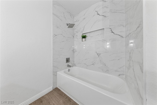 bathroom with tiled shower / bath and wood-type flooring