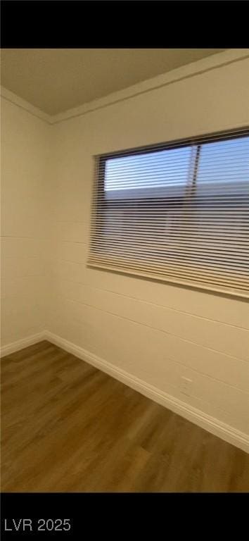 empty room with crown molding and dark wood-type flooring