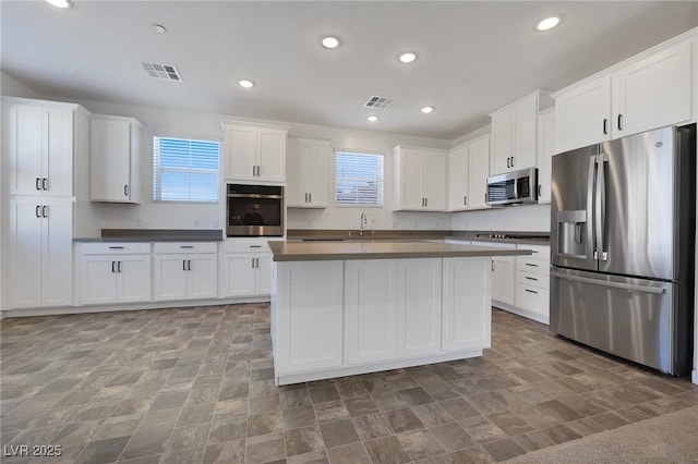 kitchen featuring sink, stainless steel appliances, a center island, and white cabinets